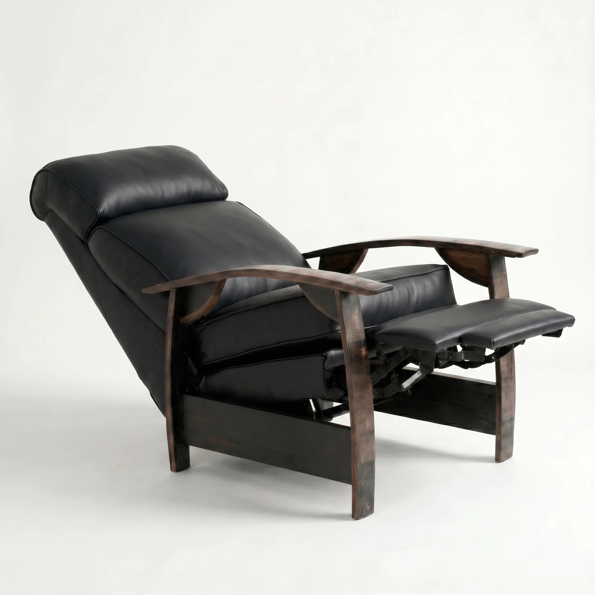 Black leather whiskey barrel recliner reclined with footrest extended and oak whiskey-barrel stave armrests, on a white background
