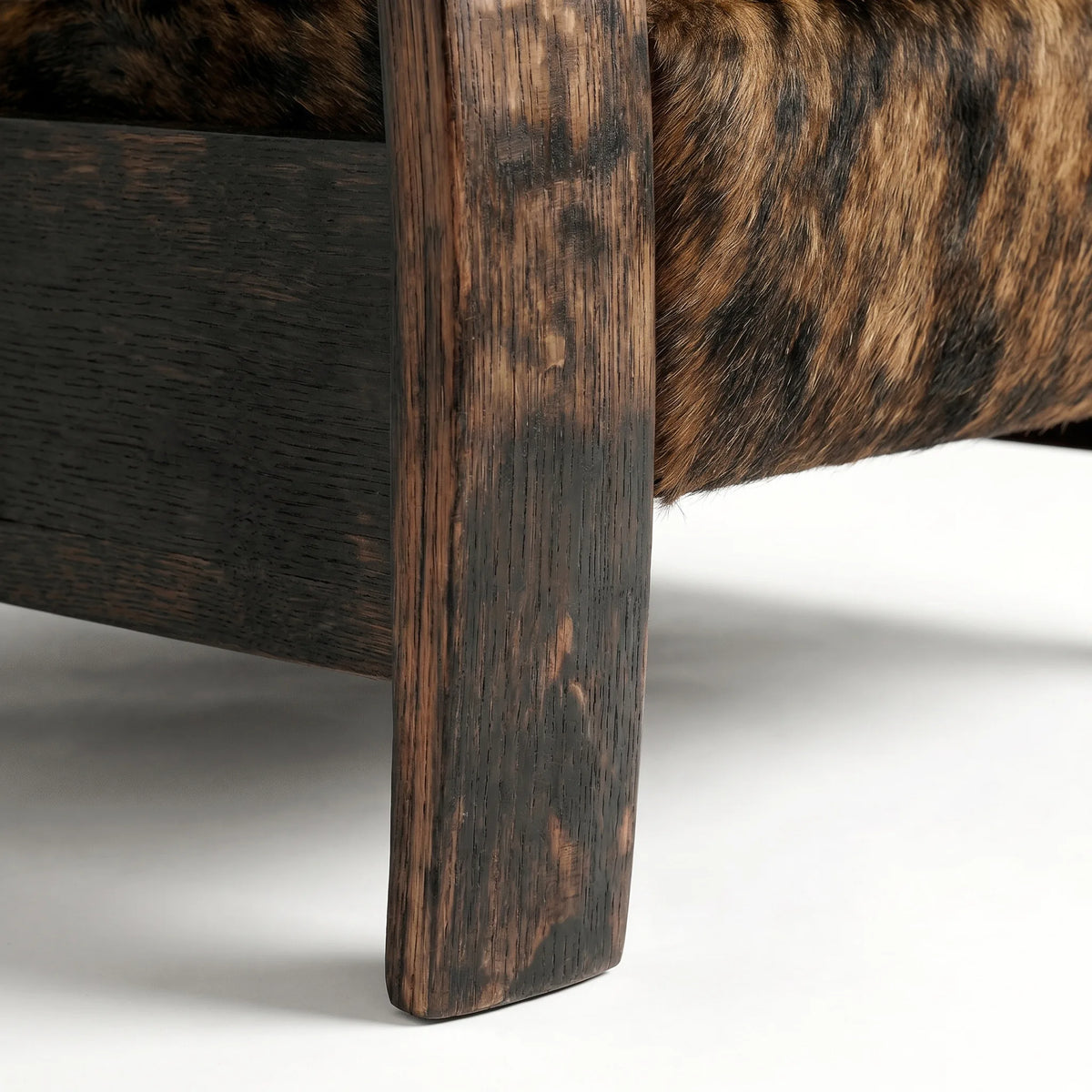Close-up of the Extra Tall whiskey barrel recliner's oak whiskey-barrel stave leg in brindle cowhide, on a white background