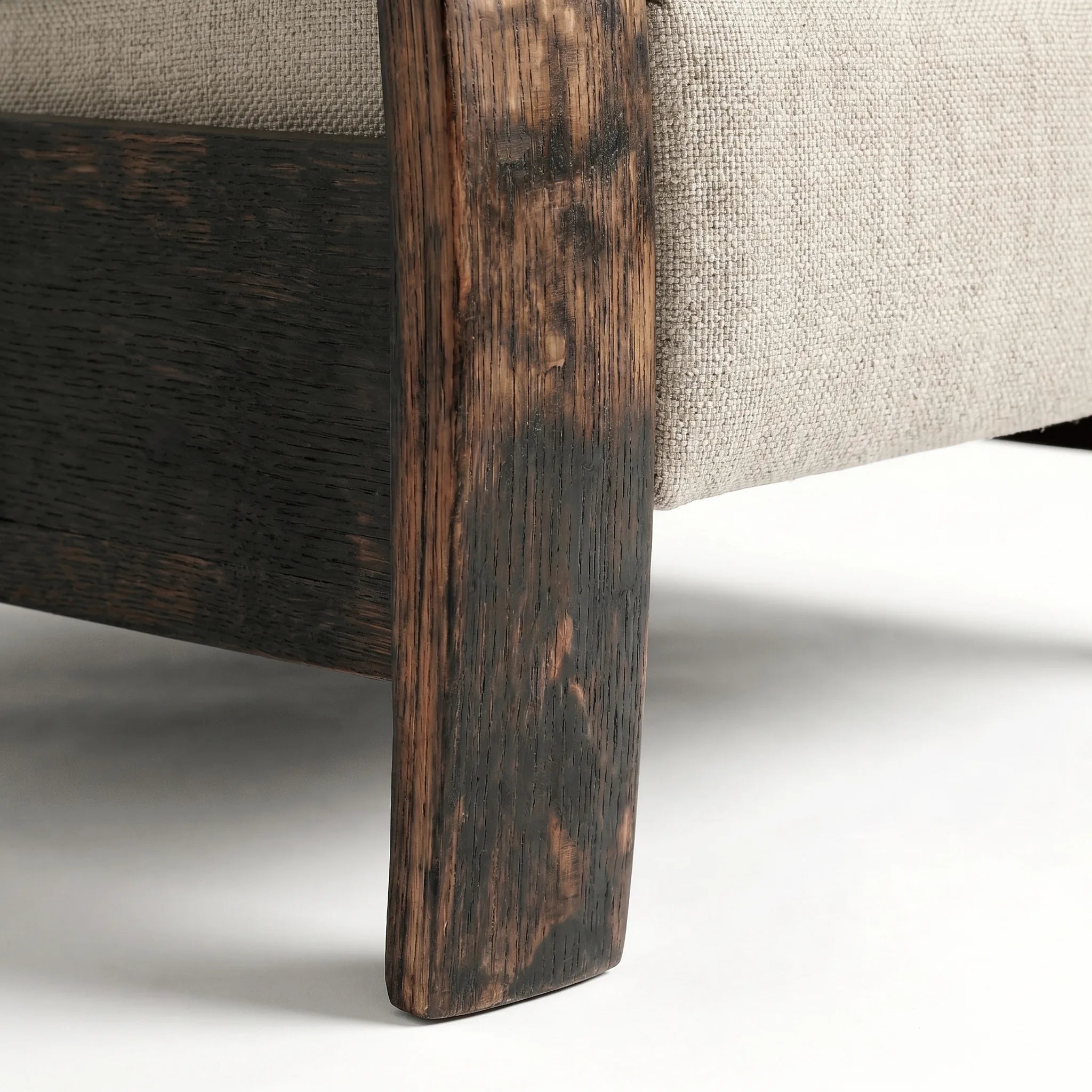 Close-up of the Big & Tall whiskey barrel recliner's oak whiskey-barrel stave leg in oatmeal gray plush fabric, on a white background