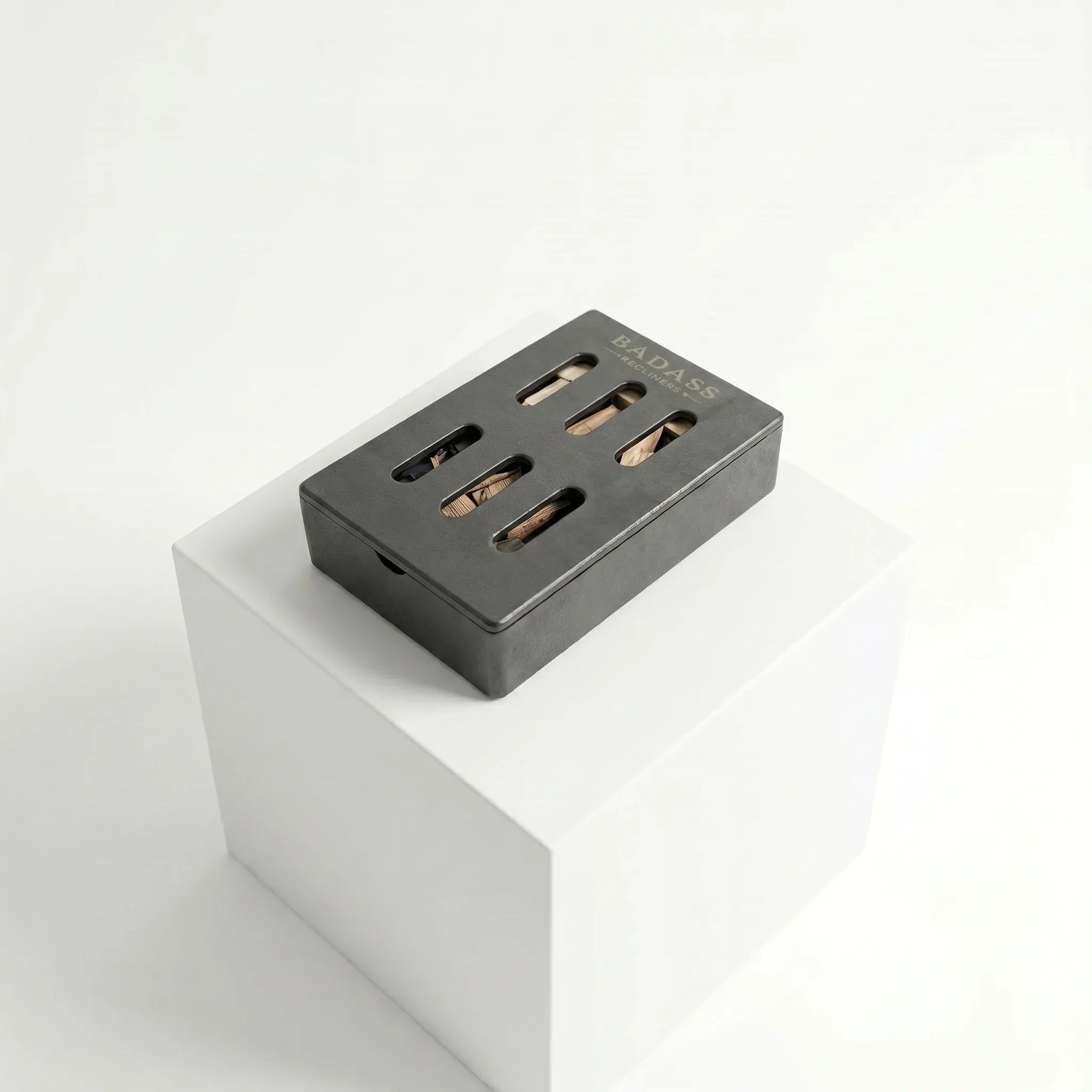 Black smoker box on a white pedestal with a white background