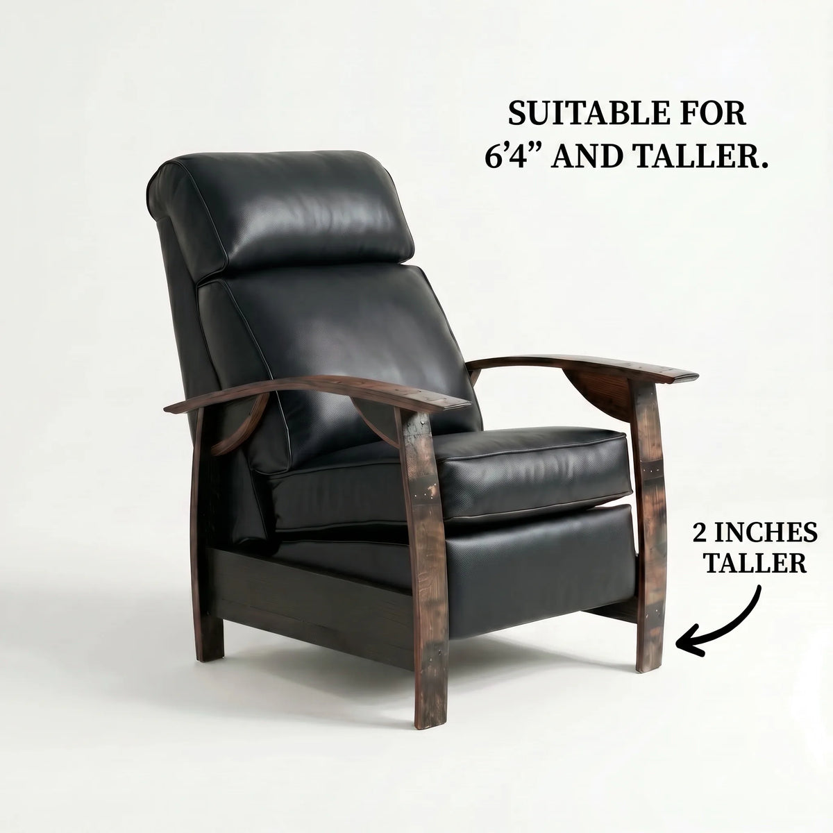 Big & Tall whiskey barrel recliner chair in smooth black full-grain leather with oak whiskey-barrel stave armrests, upright, on a white background, labelled suitable for 6'4" and taller with legs 2 inches taller