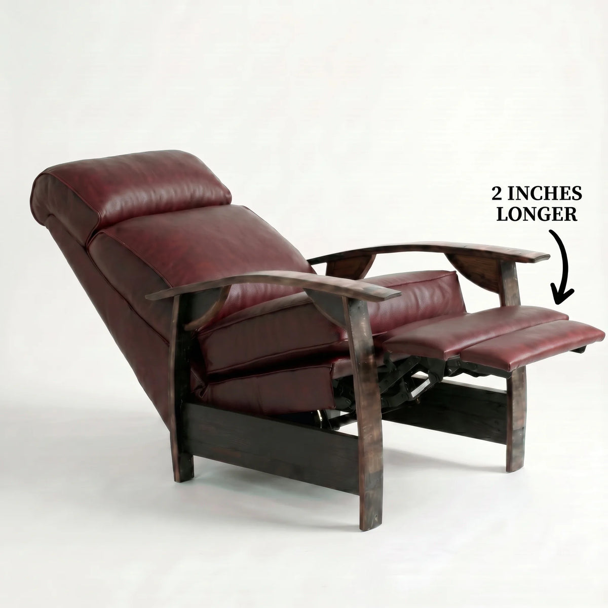 Extra Tall oxblood leather whiskey barrel recliner reclined with the 2-inch-longer footrest extended and oak whiskey-barrel stave armrests, on a white background