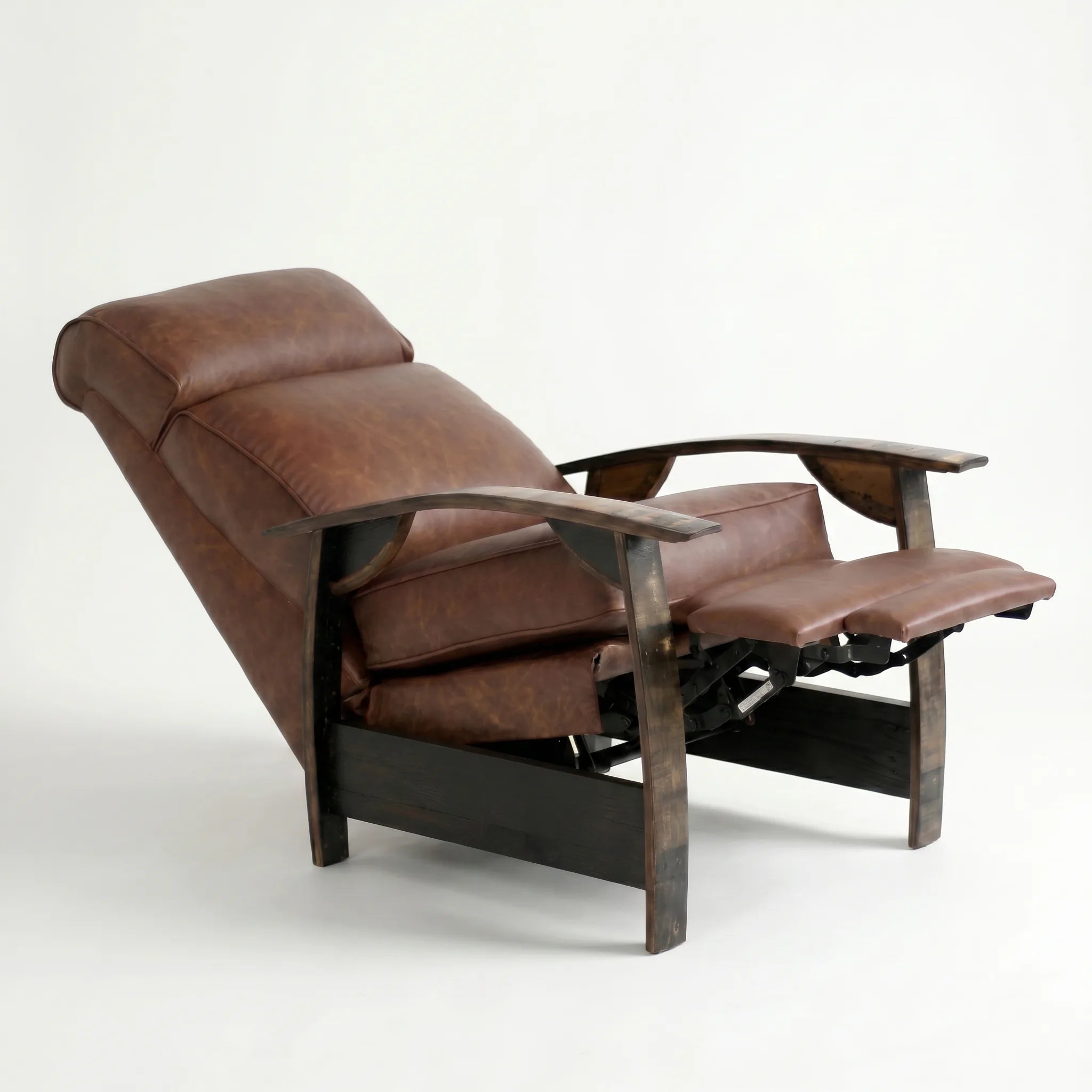 Whiskey-brown leather whiskey barrel recliner reclined with footrest extended and oak whiskey-barrel stave armrests, on a white background