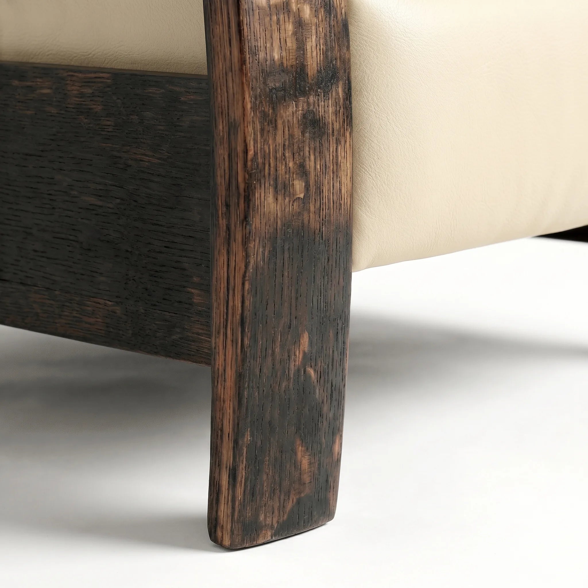Close-up of the Big & Tall whiskey barrel recliner's oak whiskey-barrel stave leg in cream ivory leather, on a white background