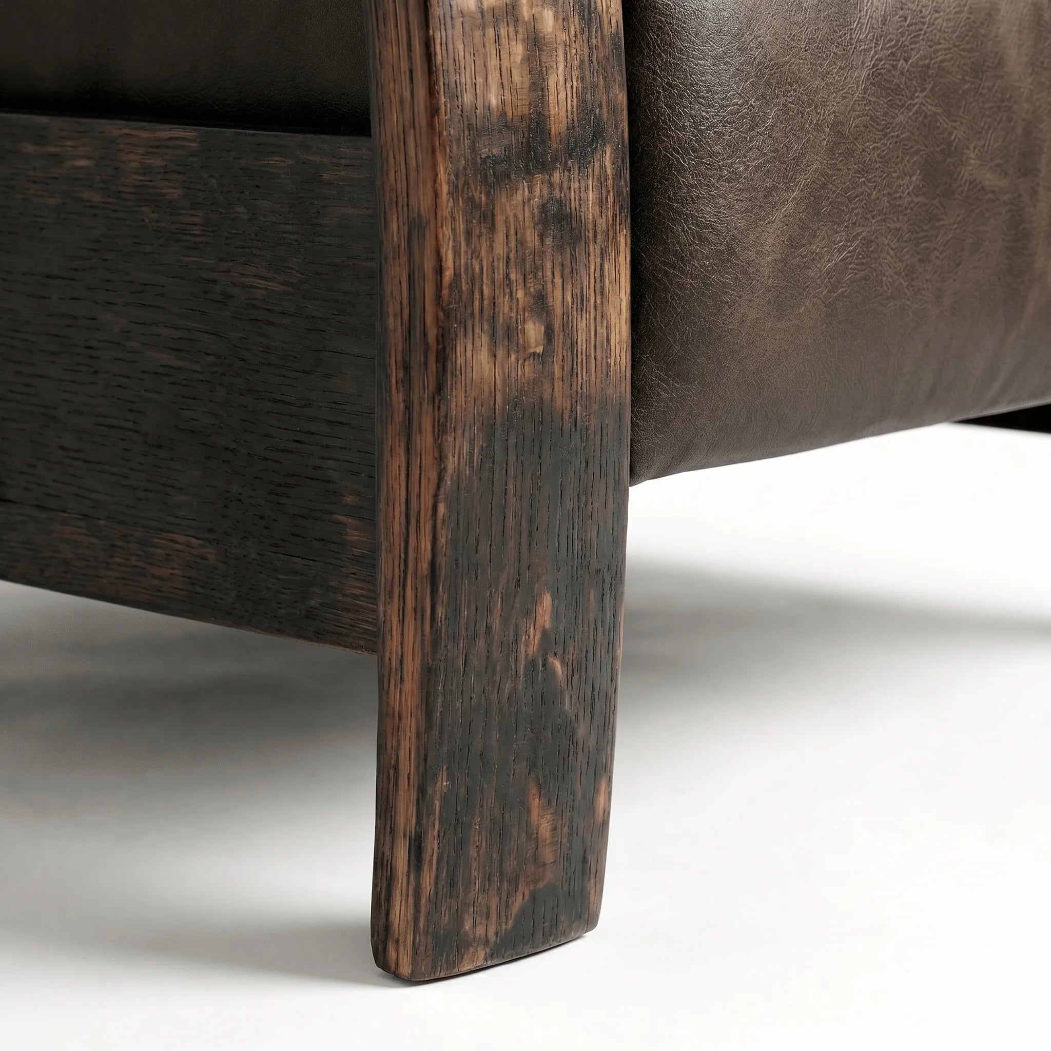 Close-up of the Big & Tall whiskey barrel recliner's oak whiskey-barrel stave leg in cognac brown leather, on a white background