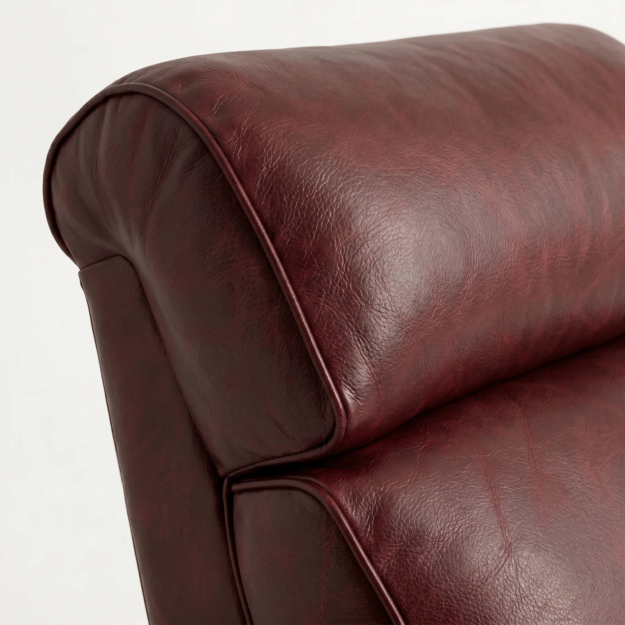 Close-up of the Big & Tall oxblood leather whiskey barrel recliner headrest and cushion, on a white background