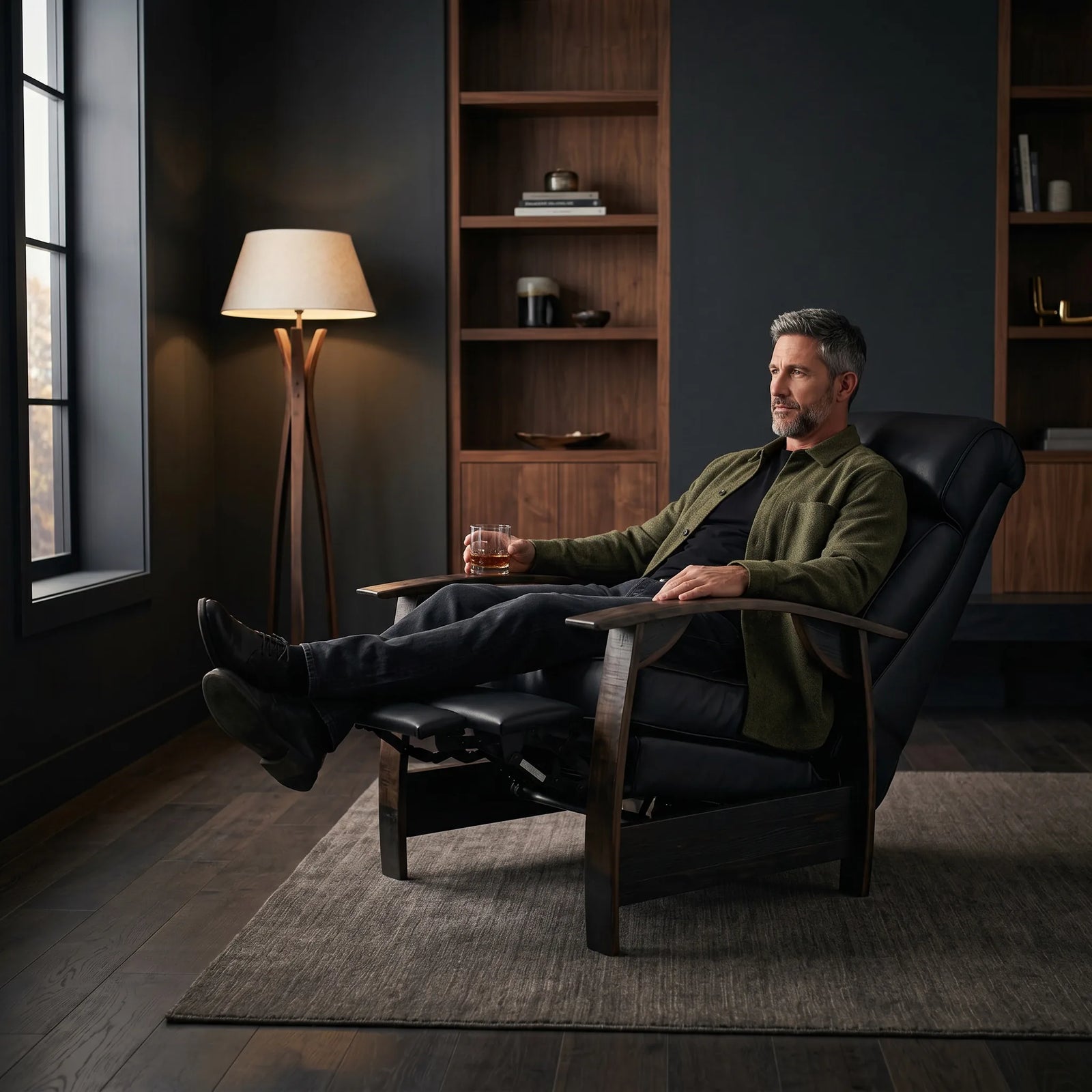 Man relaxing in a black leather whiskey barrel recliner in a dark modern lounge