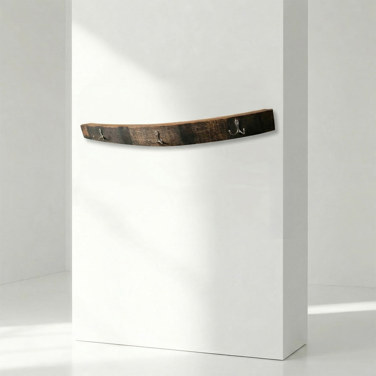 whiskey barrel stave as a coat hanger with hooks on a white background